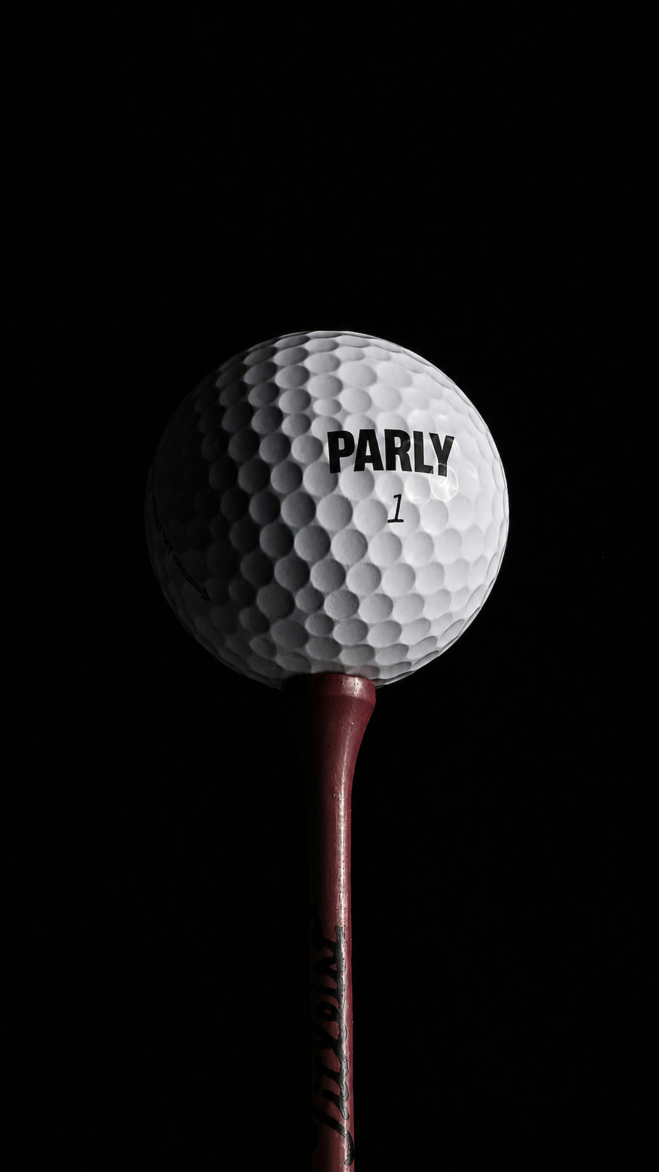 A PARLY golf ball on a tee against a black background