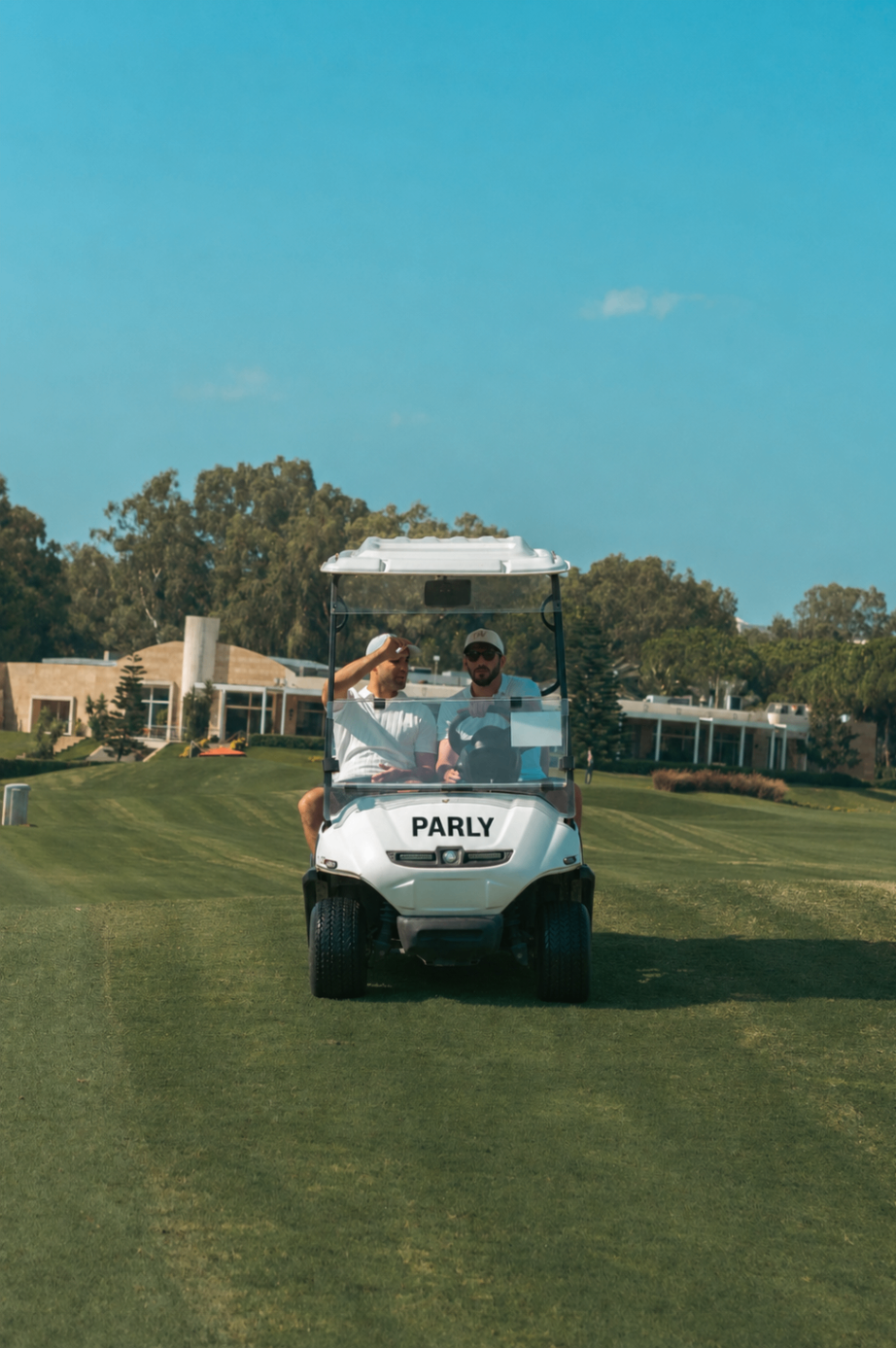 Two golfers driving a PARLY-branded golf cart
